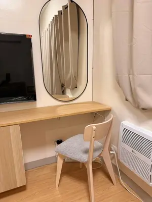 a mirror and a chair in front of a desk at Morgan Suites Executive Residences 3 in Manila