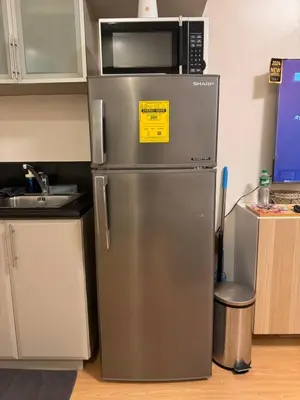 a stainless steel refrigerator in a kitchen with a microwave at Morgan Suites Executive Residences 3 in Manila