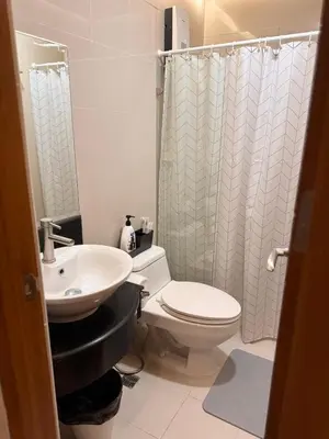 a bathroom with a white toilet and a sink at Morgan Suites Executive Residences 3 in Manila