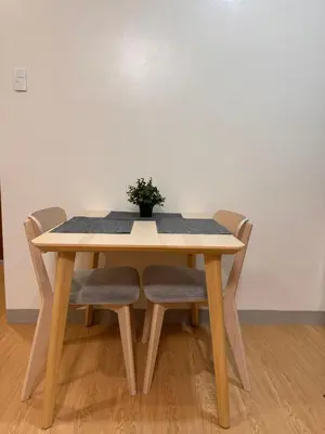 a wooden table with chairs and a plant on it at Morgan Suites Executive Residences 3 in Manila