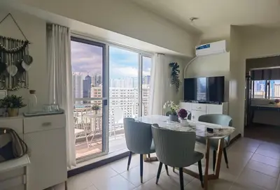 a kitchen and dining room with a table and a large window at pasig city resort condo in Manila