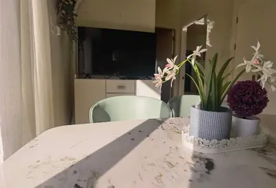 a white table with a vase with flowers on it at pasig city resort condo in Manila