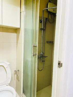 a bathroom with a shower and a toilet at Shell Residences Condotel by Aiza in Manila