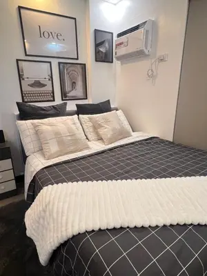 two beds sitting next to each other in a bedroom at Aesthetic 2BR Penthouse near NAIA with Pool in Manila