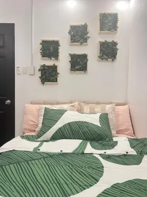 a bedroom with a bed with green and white sheets at Aesthetic 2BR Penthouse near NAIA with Pool in Manila
