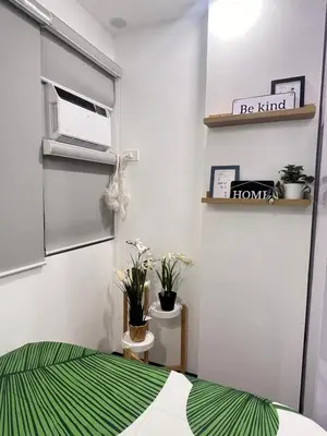 a small room with a bed and a microwave at Aesthetic 2BR Penthouse near NAIA with Pool in Manila