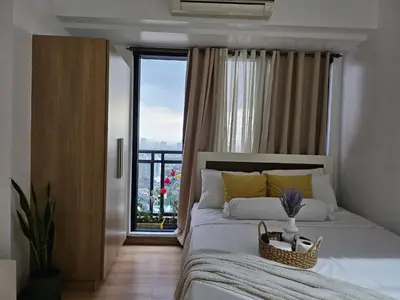 a bedroom with a bed and a large window at Room with stunning view in Makati in Manila