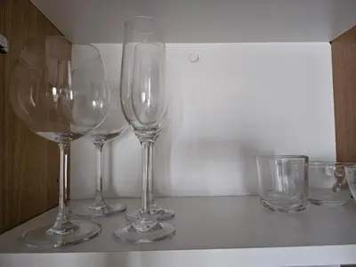 four wine glasses sitting on top of a counter at Room with stunning view in Makati in Manila