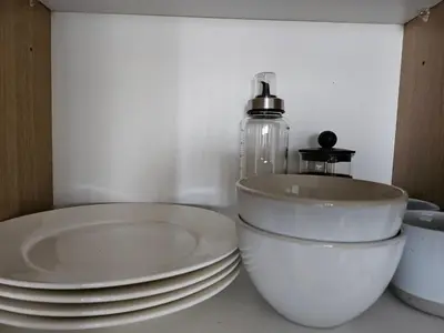a group of white plates and a bottle on a counter at Room with stunning view in Makati in Manila