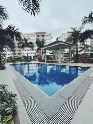 a swimming pool with a gazebo next to a building at The Stars Lil' Suite in Trece Martires