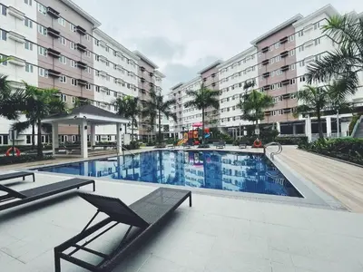 a swimming pool in front of a building at The Stars Lil' Suite in Trece Martires