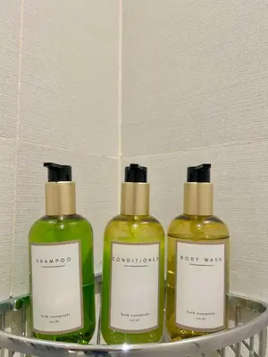 three bottles of soap on a shelf in a bathroom at Bahay-Bahayan in Manila