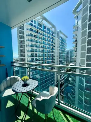 a balcony with a table and chairs and a view of a city at Bahay-Bahayan in Manila