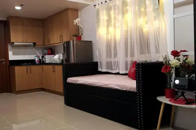 a kitchen with a couch in the middle of a room at Shell Residences Mall of Asia FAMILY ROOM in Manila