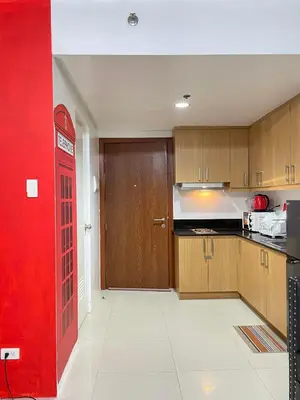 a kitchen with a red phone booth in a room at Shell Residences Mall of Asia FAMILY ROOM in Manila
