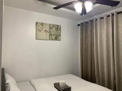 a bedroom with a bed and a ceiling fan at Birch Tower a4 front of Robinson Mla FREEpool in Manila