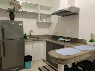 a kitchen with a counter and a sink and a refrigerator at Birch Tower a4 front of Robinson Mla FREEpool in Manila
