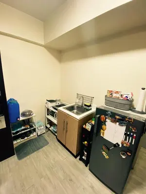 a kitchen with a sink and a refrigerator at The Gamer's Hub in Manila