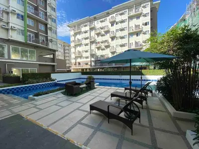 a patio with chairs and an umbrella and a pool at The Gamer's Hub in Manila