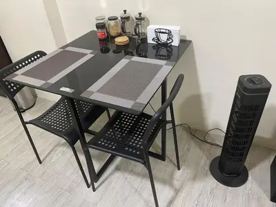 a black table with two chairs and a table and a trash can at The Gamer's Hub in Manila