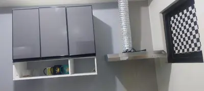 a kitchen with a glass cabinet with a light on it at Florida sun condo in Manggahan