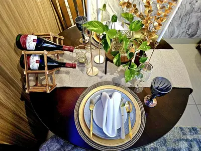 a table with a plate of napkins and wine bottles at Irene's Luscious Place in Manila