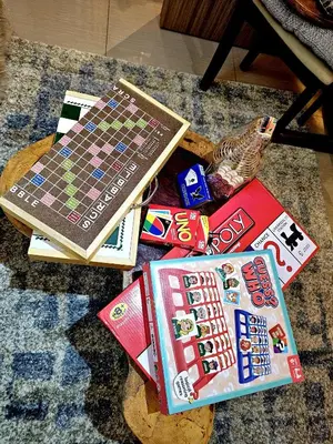 a table with books and a board game on it at Irene's Luscious Place in Manila