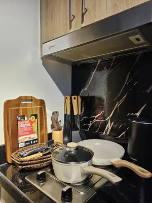 a kitchen counter with a stove with a pan on it at Irene's Luscious Place in Manila