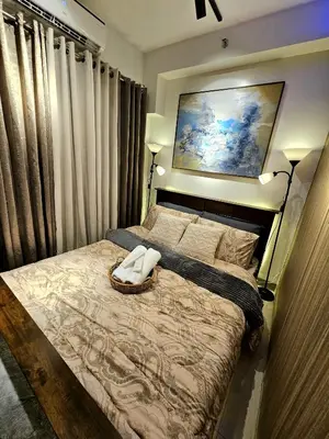 a bedroom with a bed with a painting on the wall at Irene's Luscious Place in Manila