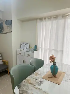 a table with a vase with a flower in a vase at Brixton Place in Manila
