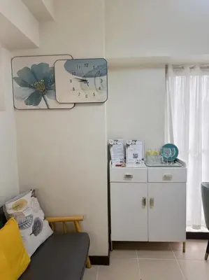 a living room with a clock on the wall at Brixton Place in Manila