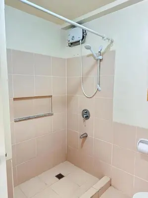 a bathroom with a shower with a toilet at Brixton Place in Manila