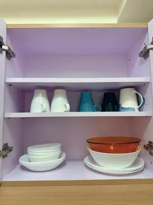 a shelf filled with plates and bowls and dishes at Brixton Place in Manila