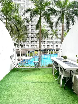 a balcony with a table and chairs and a pool at MOA Shell Residences - Big Balcony Facing Pool in Manila