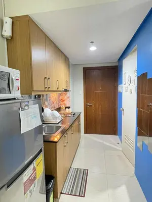 a kitchen with a sink and a refrigerator at MOA Shell Residences - Big Balcony Facing Pool in Manila