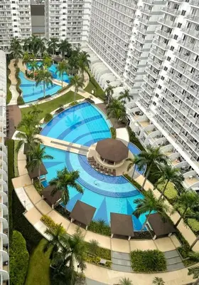 an aerial view of a resort pool with palm trees and buildings at MOA Shell Residences - Big Balcony Facing Pool in Manila