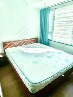 a bed sitting in a bedroom with a window at The Rise Makati in Manila