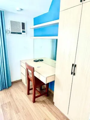 a room with a wooden table and a chair at The Rise Makati in Manila