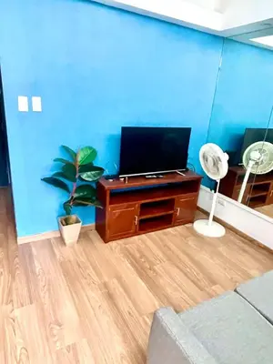 a living room with a desk with a laptop on it at The Rise Makati in Manila