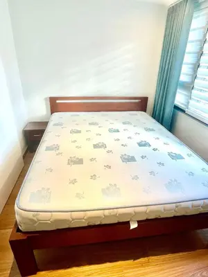 a bed in a bedroom with a bed frame and a window at The Rise Makati in Manila