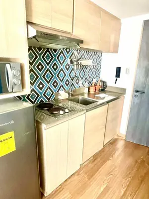 a kitchen with a sink and a refrigerator at The Rise Makati in Manila