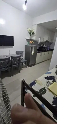 a hand holding a remote control in a kitchen at Jhang places sea residence in Manila