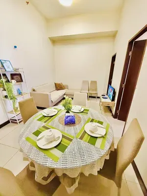 a table in a living room with a table and chairs at Vincondotel Malate Manila 2BR Admiral 2823 in Manila
