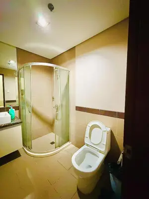 a bathroom with a shower and a toilet and a sink at Admiral Baysuites 2823 in Manila