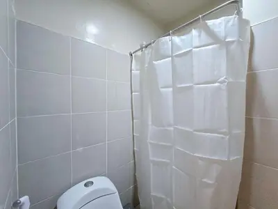 a white bathroom with a toilet and a shower at 1BR Condotel Ridgewood Towers Taguig City #RW16 in Manila