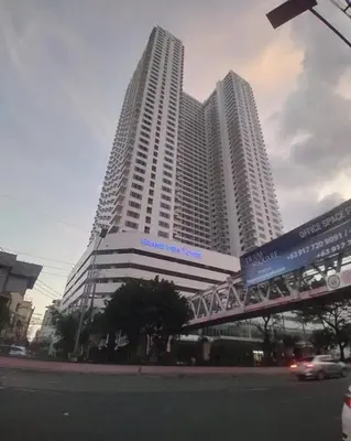 two tall buildings with a car in front of them at Grand View Tower in Manila
