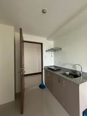 a kitchen with a sink and a door to a room at Grand View Tower in Manila
