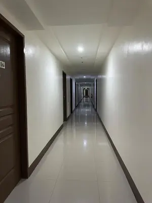 a hallway of a building with white walls and white floors at Grand View Tower in Manila