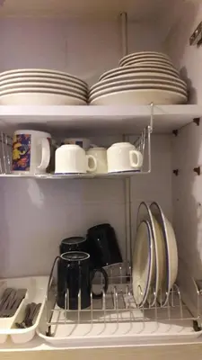 a kitchen shelf with dishes and plates on it at Araneta Cubao No Brown Outs 1BR Furnished Condo with Balcony free WiFi Netflix in Manila