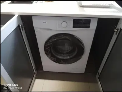 a washing machine in a cabinet under a counter at Araneta Cubao No Brown Outs 1BR Furnished Condo with Balcony free WiFi Netflix in Manila